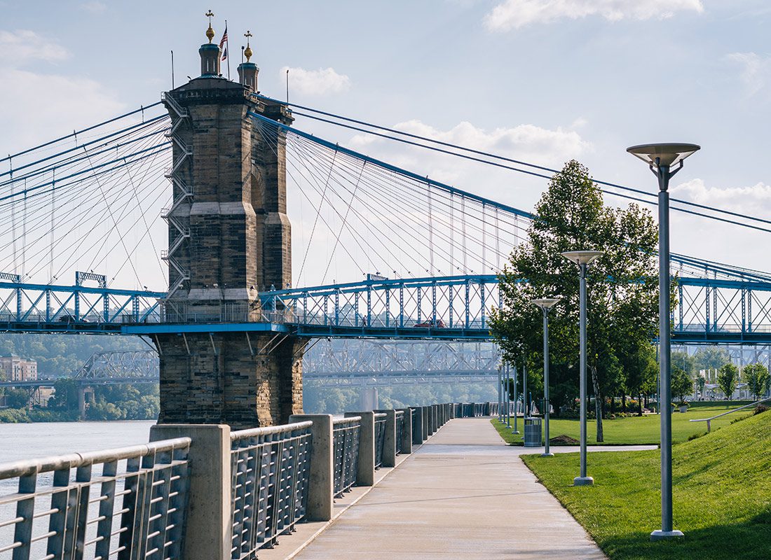 About Our Agency - Cincinnati, Oh Bridge and a Walking Path Along the Ohio River on a Sunny Day